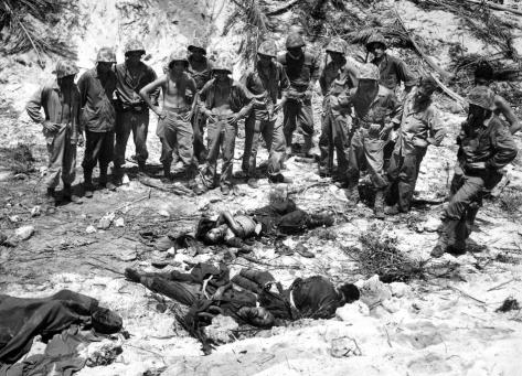 U.S. Marines inspect the bodies of three Japanese soldiers killed in the invasion at Peleliu island at the Palau group, September 16, 1944. (AP Photo/Joe Rosenthal)